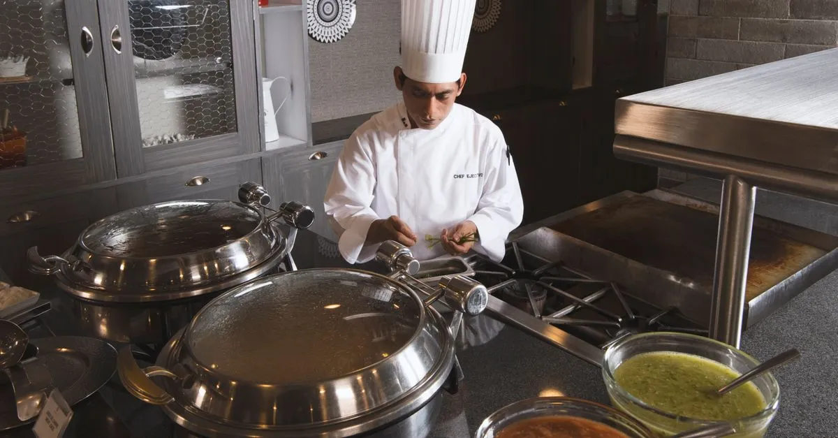 A chef preparing food at a live station in a buffet.