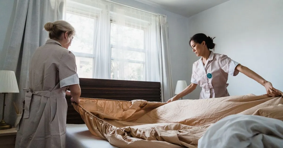 A housekeeper cleaning a hotel guest room.